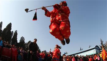 People view folk art performance in China's Yantai